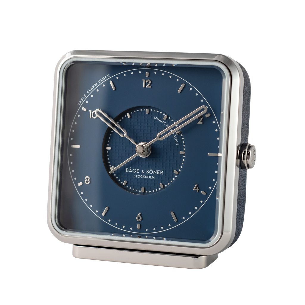 Sleek 'Northern Lights' alarm clock with a blue dial and silver numbers, paired with polished stainless steel