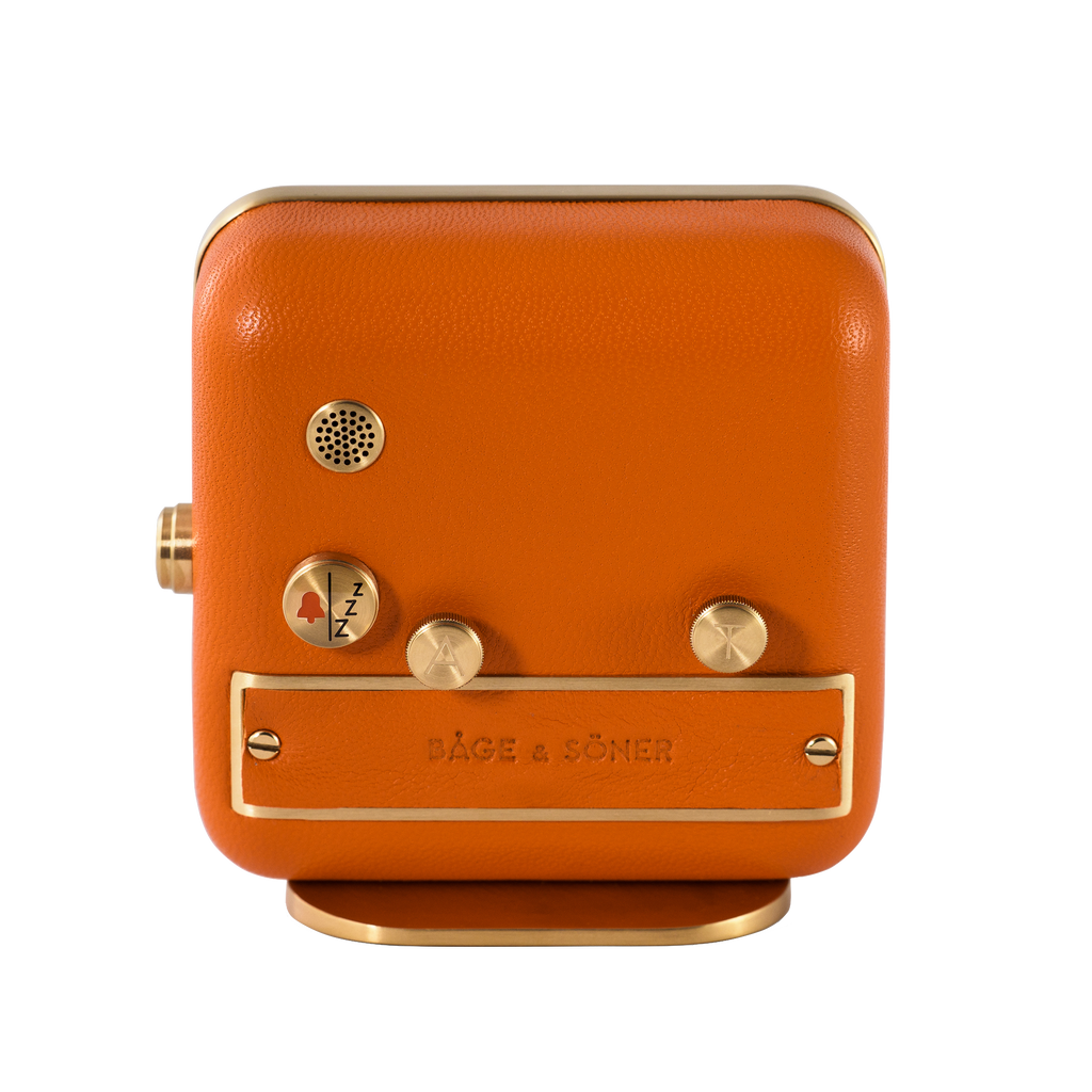 Rear view of 'Everglow' alarm clock showing the brushed gold-plated back and orange leather craftsmanship