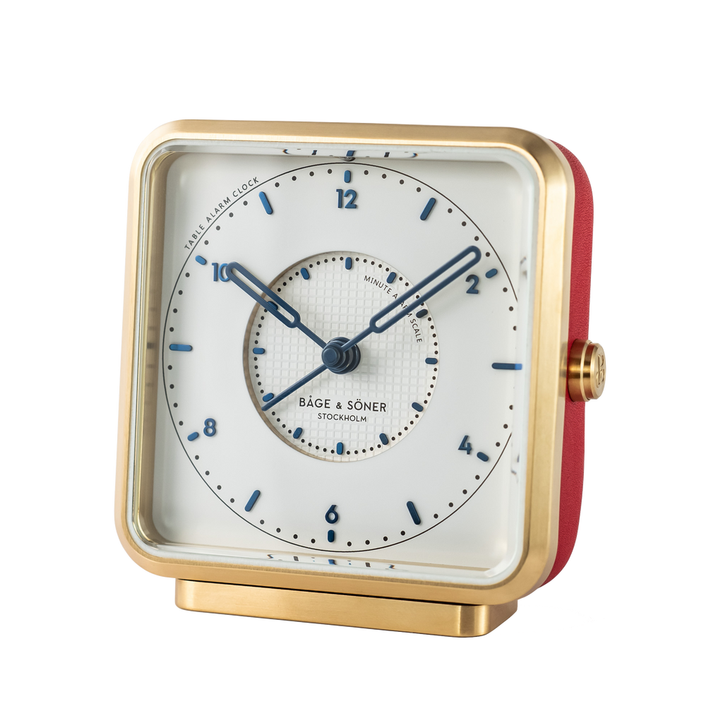 Elegant 'French Kiss' alarm clock with a white dial, blued numbers, and Tapisserie pattern