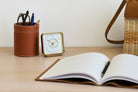 Luxurious 'Happy Yawn' alarm clock on wooden bedside table, blending with the room's aesthetics